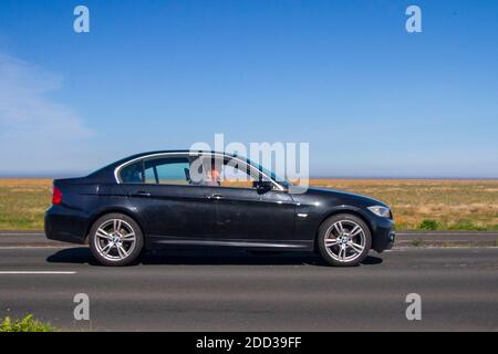 2011 BMW 320D M Sport 181 noir ; circulation automobile, véhicules en mouvement, voitures, conduite de véhicules sur les routes britanniques, moteurs, conduite sur la promenade de bord de mer de Southport, Royaume-Uni Banque D'Images