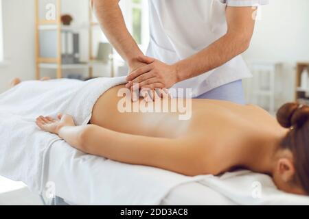 Masseuse professionnelle effectuant un massage du dos pour une jeune femme allongé table de massage au centre de remise en forme Banque D'Images