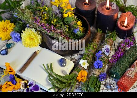 Encore la vie avec bol d'herbes, bougies et vieux livre sur table de sorcière. Concept ésotérique, occulte et mystique, médecine alternative de fond avec naturel Banque D'Images