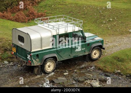 Land rover d'un garde-forestier du National Trust traversant un ruisseau dans la vallée de l'usine de Carding, Shropshire, Angleterre, Royaume-Uni. Banque D'Images