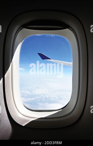 Vue aérienne d'un avion volant dans le ciel à travers fenêtre Banque D'Images