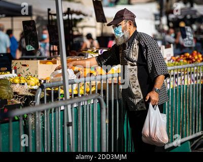 Chalon en Champagne, France - 07 août 2020 : homme avec masque facial achetant sur un marché par une chaude journée ensoleillée en été Banque D'Images