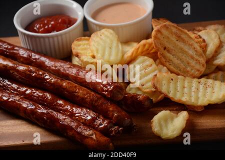 Saucisses grillées avec frites maison et sauce, ketchup Banque D'Images