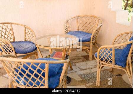 chaises en bois d'osier et table basse pour se détendre et socialiser en famille ou entre amis sur la terrasse extérieure du village de la maison Banque D'Images