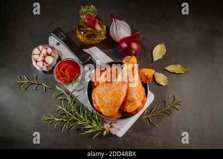 Pilon de poulet dans une poêle. Pilon de poulet dans une poêle avec épices, ail, poivron rouge. Banque D'Images