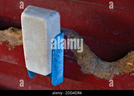 Un bloc de sel utilisé pour les animaux de ferme accroché à un mur de grange rouge. . Photo de haute qualité Banque D'Images