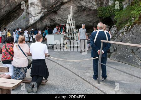 Pèlerins priant devant la grotte et les bougies. Quelques semaines avant les processions traditionnelles du 15 août, les pèlerins sont présents pour visiter la grotte sacrée et le sanctuaire de notre-Dame de Lourdes. 160 ans après les premières apparitions de la Vierge Marie à Bernadette Soubirou, les catholiques et les chrétiens sont encore nombreux à venir du monde entier pour invoquer, prier ou espérer. Lourdes, France, le 03 août 2018. Photo de Patrick Batard/ABACAPRESS.COM Banque D'Images