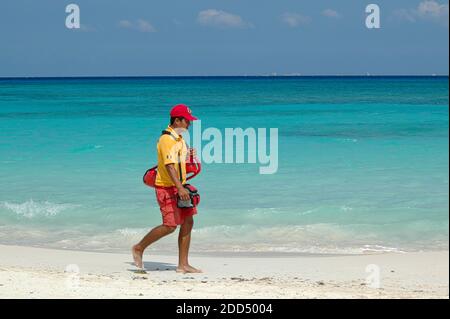 Les sauveteurs se promènont sur la plage, Playa del Carmen, Mexique. En arrière-plan l'océan des Caraïbes et le ciel bleu Banque D'Images