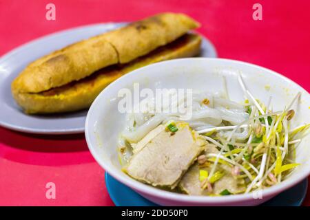 Plat de nouilles d'inspiration vietnamienne locale appelé chaolong et sandwich au pain français à Puerto Princesa City, Palawan, Philppines Banque D'Images