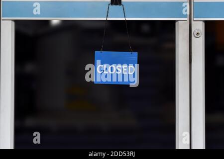 Un panneau "fermé" accroché à la porte vitrée d'un magasin, fermé en raison de difficultés financières et de crise économique. Banque D'Images