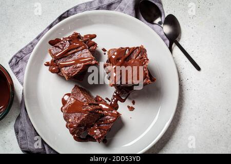 Carrés de brownie vegan avec chocolat noir sur une assiette grise, vue du dessus. Concept de dessert végétalien. Banque D'Images