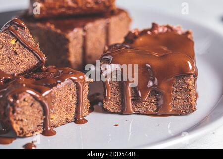 Carrés de brownie vegan au chocolat noir sur une assiette grise, fond gris. Concept de dessert végétalien. Banque D'Images