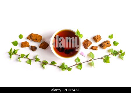 Tasse de thé de champignon chaga de bouleau et chaga écrasé morceaux de champignons pour la préparation du thé isolés sur fond blanc Banque D'Images