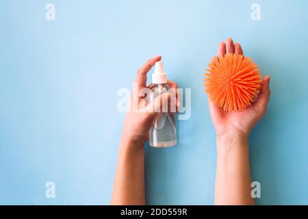 Traitement des mains avec l'alcool antiseptique, concept créatif de la lutte contre les virus. À la main, vaporisez de l'assainisseur sur le symbole du virus. Banque D'Images