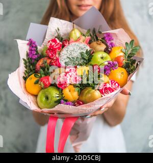 Bouquet de fruits et de baies. Bouquet de l'alimentation de femmes. Apple, orange, fraise, poire, kiwi, fruit du dragon et des fleurs, de l'eucalyptus. Shallow DOF Banque D'Images