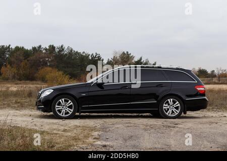 Dnipro, Ukraine - 21 novembre 2020: Mercedes-Benz E220 CDI 2011 couleur noire dans la ville d'automne près de la forêt Banque D'Images