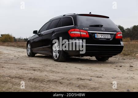 Dnipro, Ukraine - 21 novembre 2020: Mercedes-Benz E220 CDI 2011 couleur noire dans la ville d'automne près de la forêt Banque D'Images