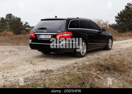 Dnipro, Ukraine - 21 novembre 2020: Mercedes-Benz E220 CDI 2011 couleur noire dans la ville d'automne près de la forêt Banque D'Images