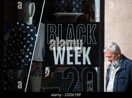 Malaga, Espagne. 24 novembre 2020. Un homme portant un masque se promène devant une publicité du Vendredi fou dans la fenêtre d'une boutique en pleine crise du coronavirus.les magasins et les boutiques du centre-ville de Malaga ont commencé la saison des ventes à l'approche du Vendredi fou le 27 novembre, avec une semaine de réductions sur leurs produits. À cette occasion, en vertu des restrictions obligatoires imposées par les magasins et magasins à proximité avant 18 heures comme mesures pour contenir la propagation de la maladie du coronavirus. Crédit : SOPA Images Limited/Alamy Live News Banque D'Images