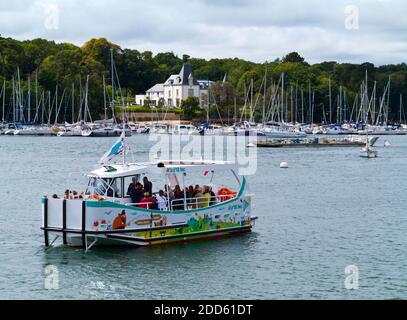 Vue d'été de Benodet ville côtière sur l'estuaire de l'Odet dans le Finistère Bretagne nord-ouest de la France avec bateau touristique en premier plan. Banque D'Images