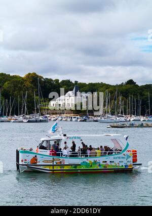 Vue d'été de Benodet ville côtière sur l'estuaire de l'Odet dans le Finistère Bretagne nord-ouest de la France avec bateau touristique en premier plan. Banque D'Images