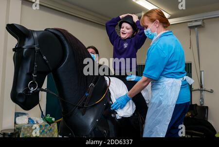 East Lothian, Écosse, Royaume-Uni, NHS Lothian & Muirfield Riding Therapy célèbre 10 ans d'hippothérapie : la physiothérapeute Heather Falconer a été la première à proposer le Children's Therapeutic Riding Service (service d'équitation thérapeutique pour les enfants) en offrant gratuitement de l'équitation thérapeutique aux enfants, aux jeunes et aux adultes handicapés. Le service a été le premier en Écosse pour les enfants ayant des problèmes de mobilité, d'équilibre, de tonus musculaire et de coordination. Oreo, un cheval mécanique, permet aux jeunes d'avoir de la physiothérapie amusante. Kyle Clark, âgé de 8 ans, fait le tour du simulateur de cheval mécanique de Racewood Banque D'Images