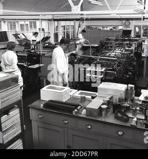 Années 1950, historiques, employés de la salle d'impression utilisant des presses à imprimer à l'usine de fabrication de peinture de Mander Brothers, Wolverhampton, Angleterre, Royaume-Uni. À cette époque, Manders était une entreprise industrielle britannique de premier plan, qui s'intéresse aux peintures et aux encres ainsi qu'à d'autres produits. Avec ses racines datant du XVIIIe siècle, l'entreprise avait toujours pris le bien-être de ses employés très au sérieux et en 1931 Mander Brothers a été la première entreprise britannique à introduire la semaine de 40 heures par le biais d'un accord historique avec Ernest Bevin, Alors secrétaire général du Syndicat des transports et des travailleurs généraux. Banque D'Images