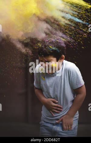 Joyeux garçon jouant avec des couleurs Holi. Banque D'Images