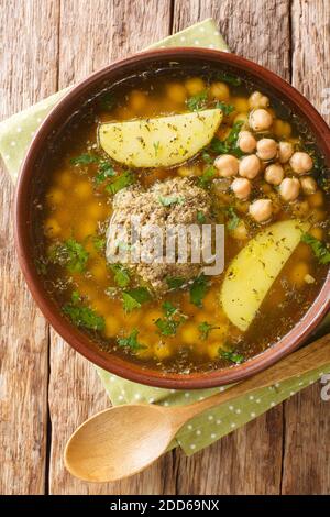 Kufta Bozbash est un plat traditionnel d'Azerbaïdjan, soupe de pois avec des boules d'agneau et des légumes dans une assiette sur la table. Vue verticale du dessus Banque D'Images