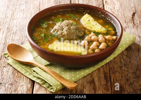 Soupe authentique de viande kufta bozbash avec boulettes d'agneau, pois chiches, légumes et herbes dans une assiette sur la table. Horizontale Banque D'Images