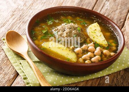 Soupe chaude au Kufta bozbash, cuite à partir de boulettes d'agneau, de pois chiches, de légumes et d'herbes, dans une assiette sur la table. Horizontale Banque D'Images