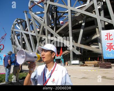 PAS DE FILM, PAS DE VIDÉO, PAS de télévision, PAS DE DOCUMENTAIRE - un responsable des Jeux Olympiques utilise une corne de taureau devant le stade national 'Bird's Nest' de Pékin, l'un des sites en construction pour les Jeux Olympiques d'été 2008. Le stade peut accueillir 91,000 spectateurs, à Beijing, en Chine, le 2 septembre 2006. Photo de Tim Johnson/MCT/Cameleon/ABACAPRESS.COM Banque D'Images