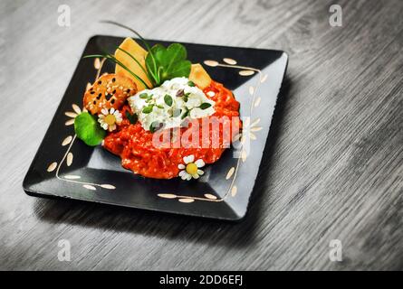 Tartiner traditionnel au poivre des Balkans - ajvar, servi avec du fromage de chèvre et des craquelins (sélection) Banque D'Images