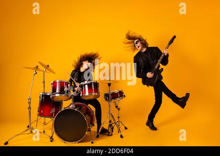 Pleine longueur photo funky fou deux personnes populaire équipe de rock homme jouer guitare basse fille tambour appréciez la performance sonore de garage vêtements de répétition de concert Banque D'Images