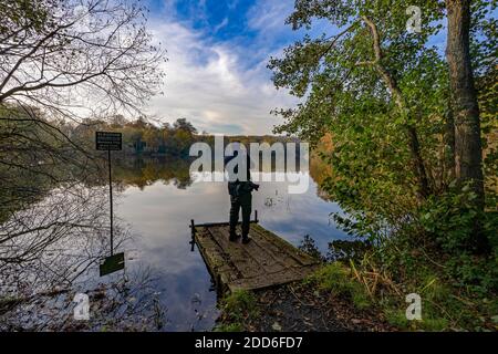 Photographe masculin photographiant l'étang du moulin de Slaugham, Slaugham, West Sussex, Angleterre, Royaume-Uni. Banque D'Images