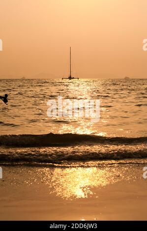 Catamaran silhouetté à Sunrise Off East Railay Beach, sud de la Thaïlande, Asie du Sud-est Banque D'Images