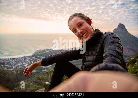 Jeune femme en vacances portant un sac à dos marchant le long du chemin côtier au coucher du soleil ou au lever du soleil, prendre le selfie pour publier sur le social multimédia avec téléphone portable Banque D'Images