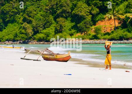 Femme transportant du poisson de retour de Selong Belanak Beach, Lombok du Sud, Indonésie, Asie Banque D'Images