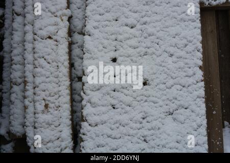 La neige blanche et douce est sur des planches en bois, la première neige à motifs différents est tombée en novembre. Banque D'Images