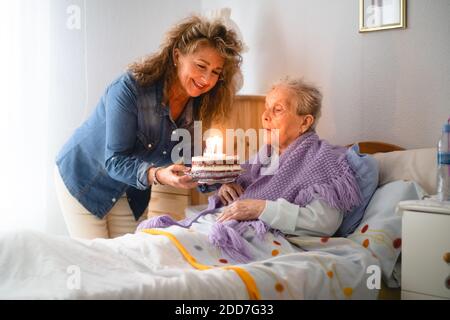 La vieille femme et la fille célèbrent son 97e anniversaire avec un gâteau Banque D'Images