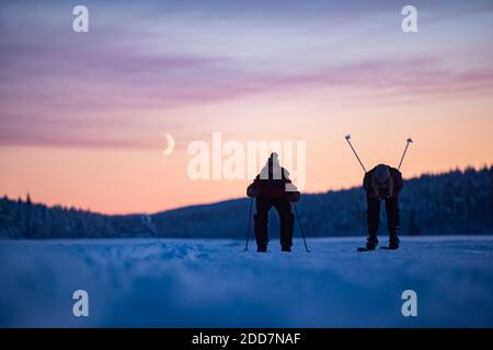 Ski sur le lac gelé à Torassieppi au coucher du soleil, Laponie, Finlande Banque D'Images