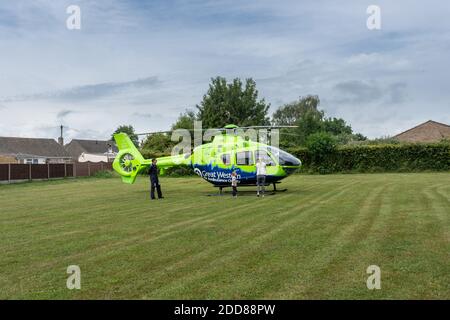 Une femme et un jeune garçon regardant le Grand Ouest Hélicoptère d'ambulance aérienne pendant que le pilote observe pendant que l'équipage médical sont ailleurs à l'incident Banque D'Images