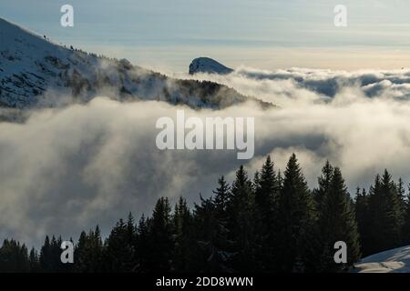 Paysage montagneux d'hiver enneigé avec des nuages et des forêts peu brumeux à la station de ski de Morzine dans la chaîne de montagnes des Alpes de France, Europe Banque D'Images