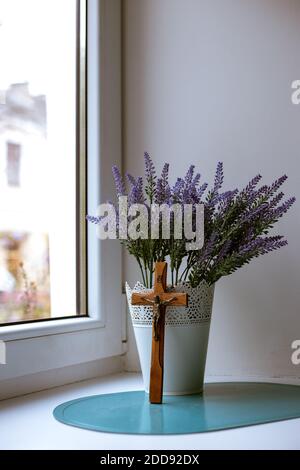 Croix en bois et bouquet de lavande près de la fenêtre Banque D'Images