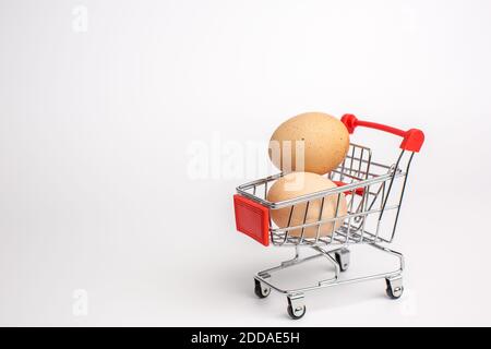 Œufs de poulet beige dans le panier. Arrière-plan blanc isolé. Concept d'alimentation saine. Banque D'Images