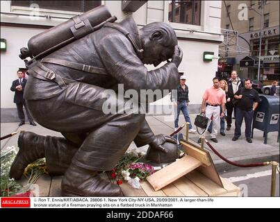 PAS DE FILM, PAS DE VIDÉO, PAS DE TV, PAS DE DOCUMENTAIRE - © RON T. ENNIS/KRT/ABACA. 28806-1. New York City-NY-USA, 20/09/2001. Une statue en bronze plus grande que nature d'un pompier en prière se trouve sur un camion à plateau à Manhattan Banque D'Images