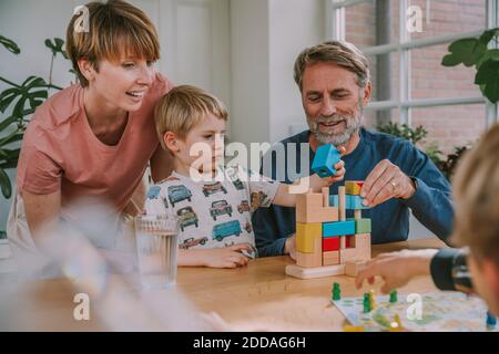 Les parents jouant avec les enfants puzzle à la maison Banque D'Images