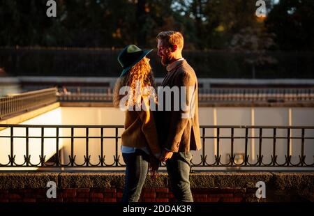 Couple marié regardant l'un l'autre en se tenant contre la main courante en ville Banque D'Images