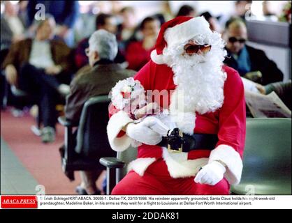 PAS DE FILM, PAS DE VIDÉO, PAS DE TV, PAS DE DOCUMENTAIRE - © ERICH SCHLEGEL/KRT/ABACA. 30595-1. Dallas-TX-USA, 23/10/1998. Son renne apparemment au sol, le Père Noël tient son petit-fille de huit semaines, Madeline Baker, dans les bras en attendant un vol vers la Louisiane à l'aéroport international de Dallas-fort Worth Banque D'Images