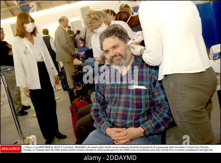 PAS DE FILM, PAS DE VIDÉO, PAS DE TV, PAS DE DOCUMENTAIRE - © SHARON PERRY/KRT/ABACA. 45151-1. LOD-Israël, 29/04/2003. Une infirmière israélienne de santé publique mesure la température corporelle d'un passager après son arrivée en Israël de Toronto, au Canada, le mardi 29 avril 2003. Le ministère de la Santé d'Israël a décidé de vérifier pas Banque D'Images